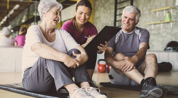 two older people with personal trainer
