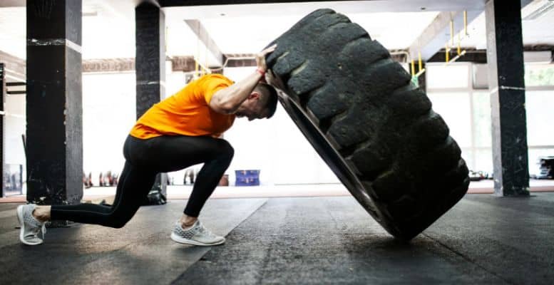 man pushing tire