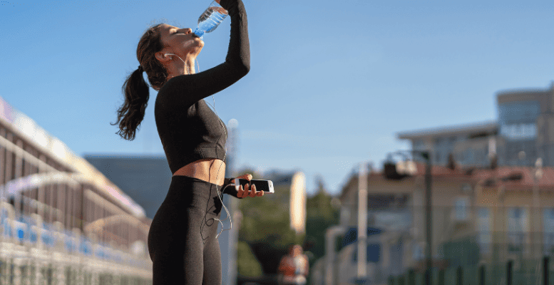 women drinking water after workout